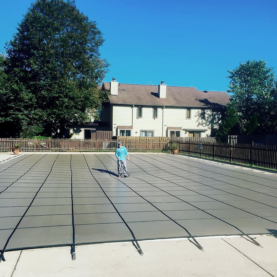 Gray mesh safety cover installed on a rectangle pool
