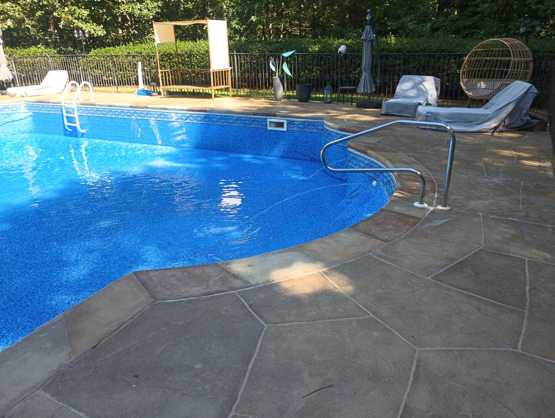 Finished pool by the step rail and flagstone deck