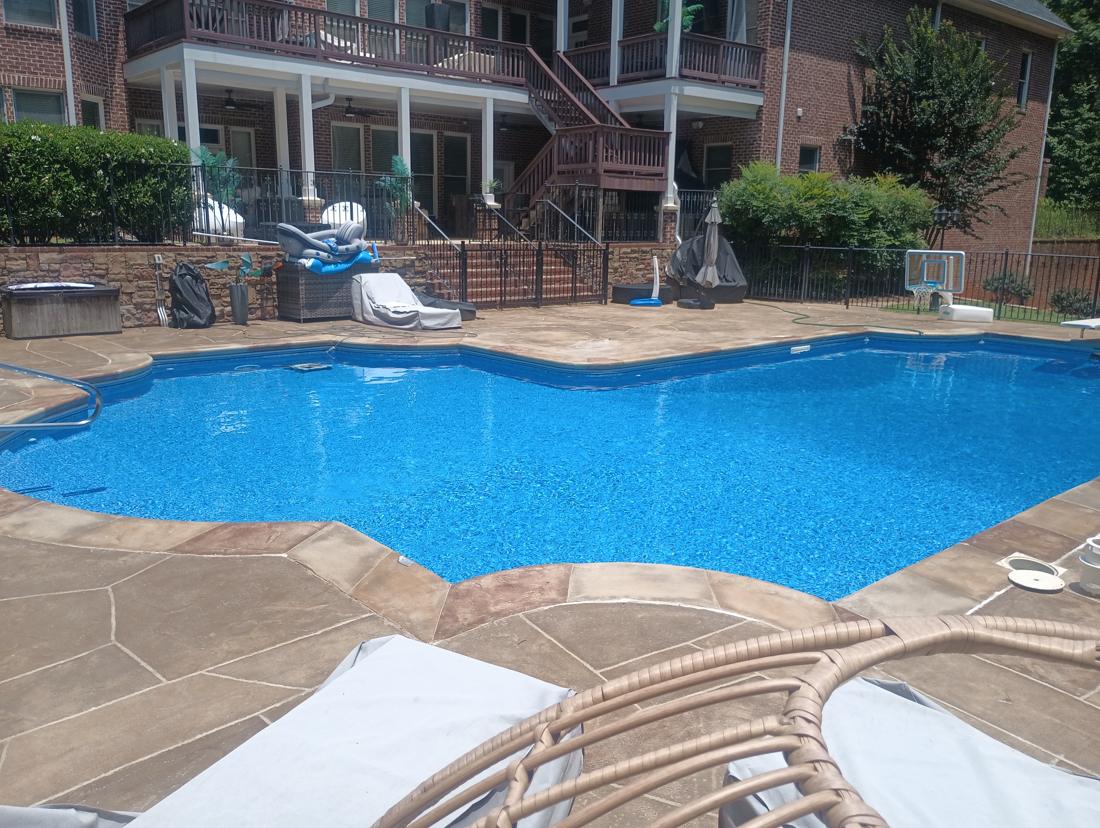 Finished pool with the house behind it