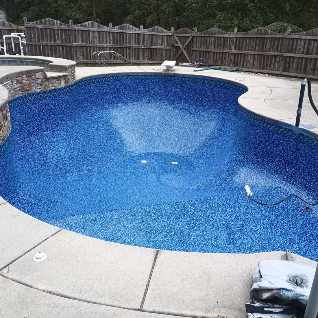 Same kidney pool with the new blue mosaic liner set and vacuumed in, before filling