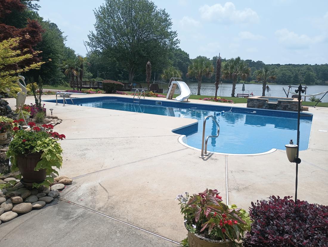 Wide view of the finished pool, spa, slide and lake