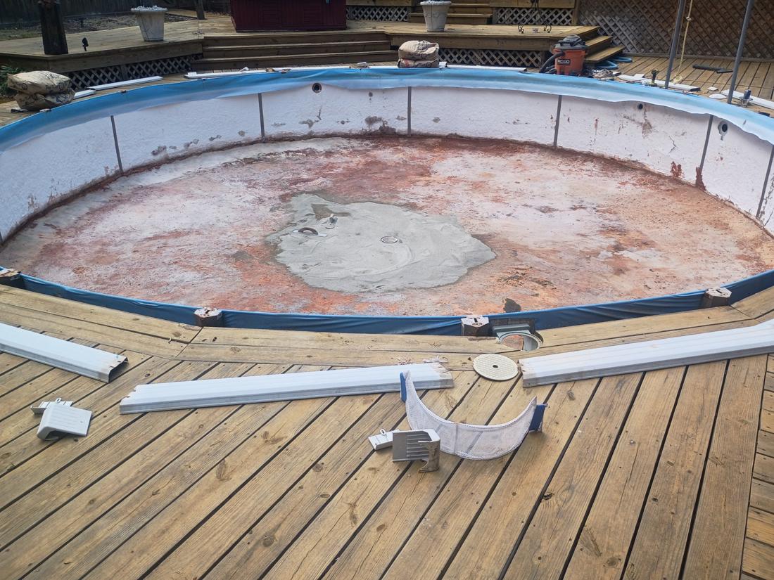 Old liner out and top rails off, showing the stained floor and walls