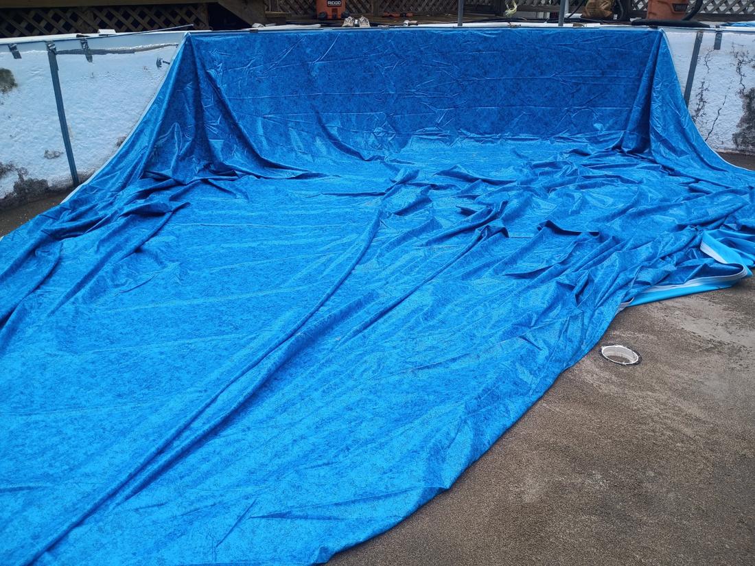 New blue liner spread out in the pool before setting